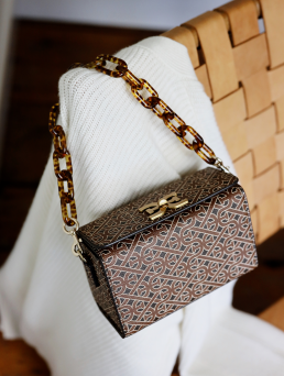 borsa marrone appoggiata su una sedia